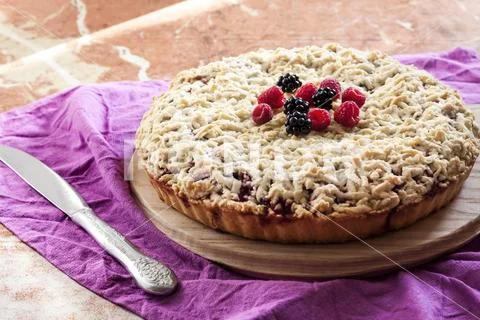Homemade shortcrust berry pie with crumble on wooden board Stock Photos