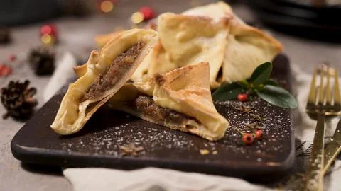 Homemade sweet triangular pastries filled with jam on a dark wooden board Stock Photos