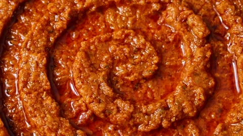 Homemade tomato and basil red pesto sauce texture circle rotation Stock Footage 277685083