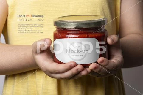 Homemade tomato paste in glass jar in little girl hands mock-up series PSD Template