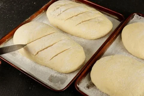 Homemade uncooked bread on rack ready for baking. Stock Photos