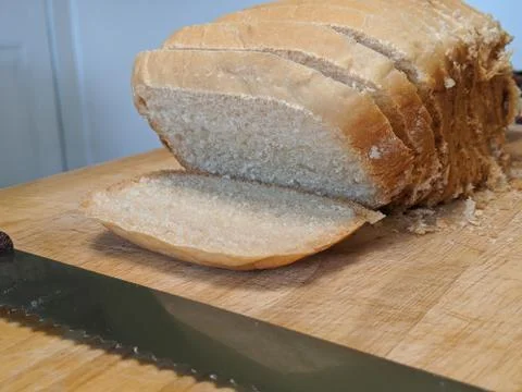 Homemade white bread on a cutting board with bread knife Stock Photos
