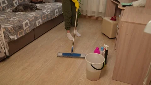 A homemaker is mopping the floor with a mop, making sure not to miss a single Video stock 312258912