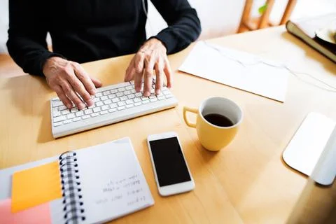 Homeoffice setup, high angle view. Man working on computer from home, typing on Foto stock