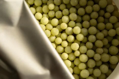 Homeopathic pellets in a container with an opened protective membrane. Stock Photos