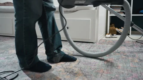 Homeowner cleans patterned rug. Casual weekday task with vacuum cleaner. House Stock Footage 342336459