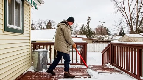 Homeowner Clearing Snow From Backyard Deck. Stock Footage 124718047