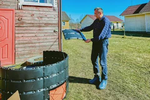 Homeowner installing compost container by joining segmented plastic panels .. Stock Photos