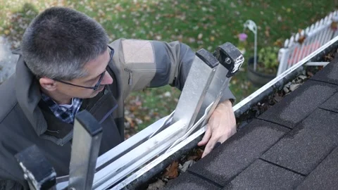Homeowner or Contractor Cleaning Full Gutters Stock Footage 320852978