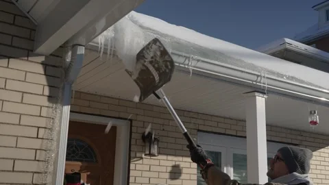 Homeowner Removes Icicles From Gutter Stock Footage 327916948
