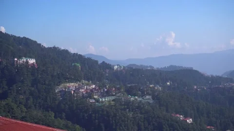 Homes built between the valley of Himachal Pradesh and surrounded by distant Stock Footage 220083608