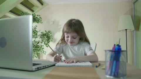 Homework With Laptop Computer.Focused Little Cute Kid Studying at Table doing Stock Footage 165333758