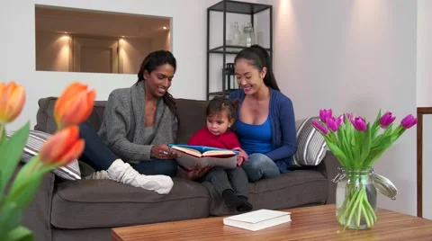 Homosexual Family With Lesbians Women Girls Reading Book To Baby Stock Footage