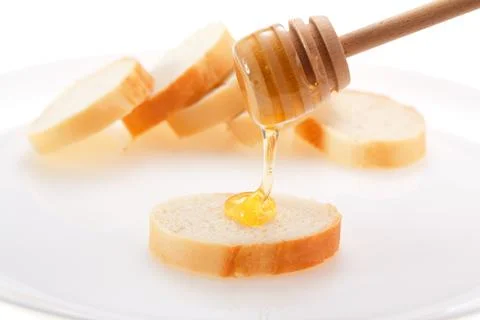 Honey is applied to the surface of bread. Isolated on a white background. Foto stock