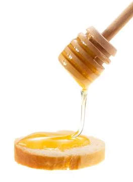 Honey is applied to the surface of bread. Isolated on a white background. Stock Photos