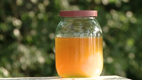 Honey background. A stream of honey flows into a glass jar, close-up. Stock-Footage 93946006