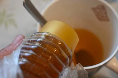 Honey being added to tea 스톡 사진