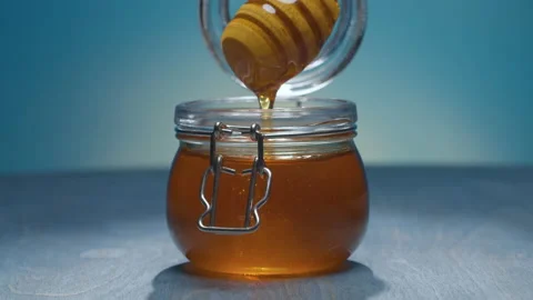 Honey on blue background Stock Footage 146259771