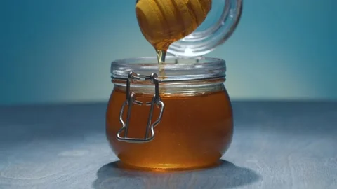 Honey on blue background Stock Footage 146308608