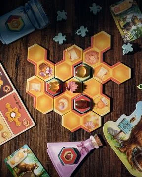 Honey Buzz board game components close up with wooden pieces honeycomb tile.. Foto stock