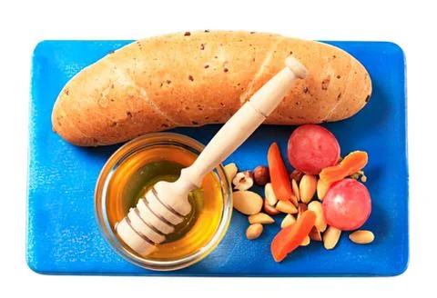 Honey dip with bread and mixed nuts on blue board Stock Photos