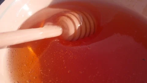 Honey Dipper.Flowing Honey. The Sun in the Background. Stock Footage
