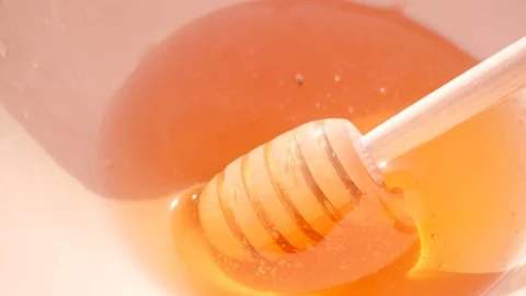 Honey Dipper.Flowing Honey. The Sun in the Background. Stock Footage