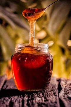Honey drip in jar on the table Stock Photos
