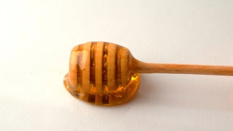 Honey dripper on white background with spot of fresh organic honey Stock Footage 91243580