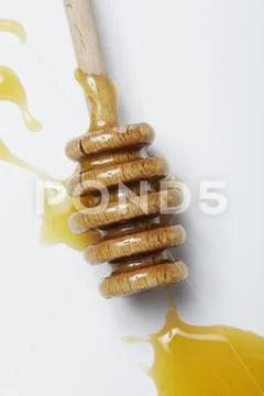 Honey dripper on white surface Stock Photos