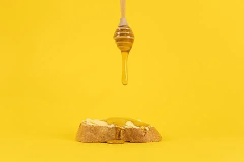 Honey dripping on bread. Stock Photos