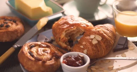 Honey dripping on a French breakfast with pastries, orange juice and coffee Stock Footage 71846292