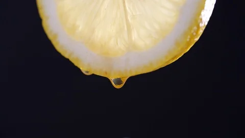 Honey dripping from slice lemon in slow motion on black background Video stock 126953239