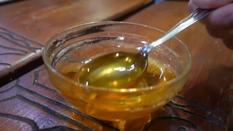 Honey dripping on a spoon. Stock Footage 72228271