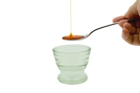 Honey dripping into spoon Stock Photos