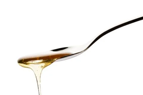 Honey falls from a spoon Stock Photos