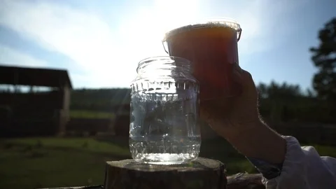 Honey flowing in a bottle Stock Footage 122243134