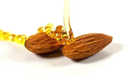 Honey flowing on two almonds Stock Footage 229420666