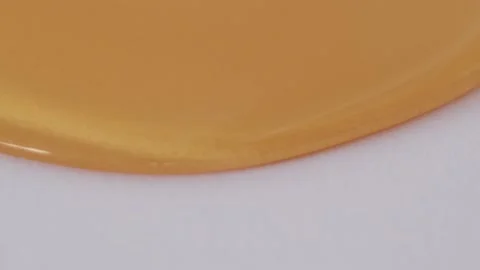 Honey flowing on a white background Stock Footage 220772977