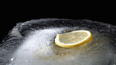 Honey flows down into ice lemon drops from above Stock Footage 85860191