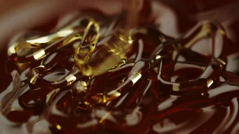 Honey flows down in a thin stream on the honey in a dark place Stock Footage 161077222