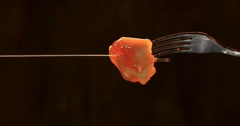 Honey flows on a piece of cheese. Cheese on a fork. Black background Stock Footage 244840898