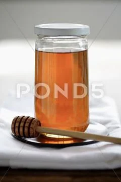 Honey in jar with dripper Stock Photos