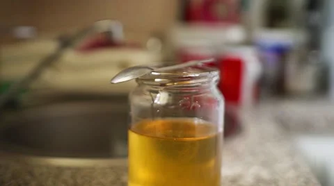 The honey jar at the kitchen table. Spoonful of honey. Dolly shot. Stock Footage 68017467
