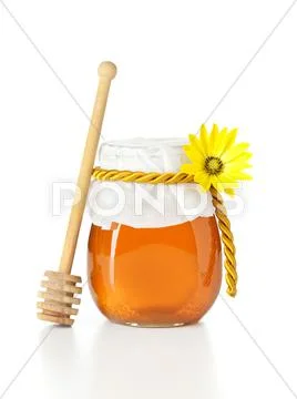 Honey jar with wooden dripper Stock Photos