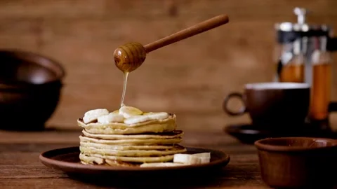 Honey or maple syrup pouring onto pancakes. Easy morning breakfast concept. Stock-Footage 336589101