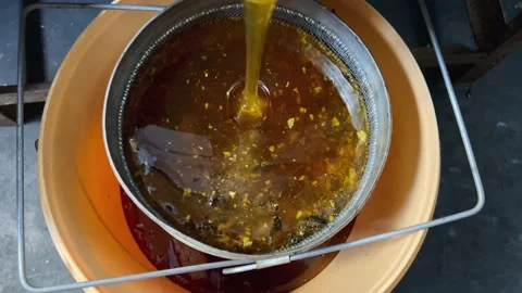 Honey passes through a filter Stock Footage 203792218