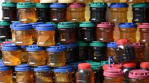 Honey in plastic jars with flying bees Stock Footage 97813030