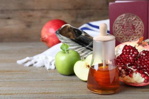 Honey, pomegranate, apples, shofar and Torah on wooden table. Rosh Hashana ho Stock Photos