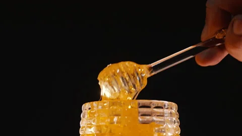 Honey pot with black background Stock Footage 166067917